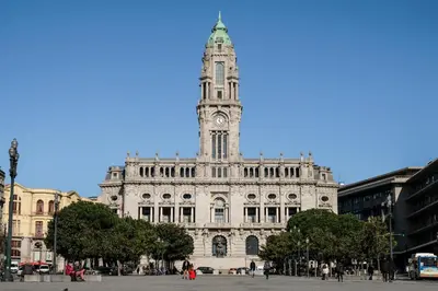 a building with a clock tower on top of it at Porto Bonjardim Apartments in Porto
