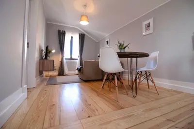 a living room with a table and white chairs at D&S - Lapa 32 in Porto