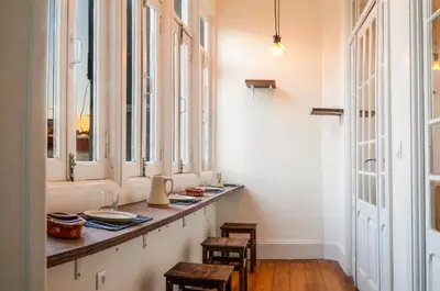 a room with a long counter with chairs and windows at METRO APARTMENT in Porto
