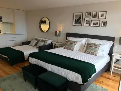 a bedroom with two beds and a mirror at Virtudes City Lofts in Porto