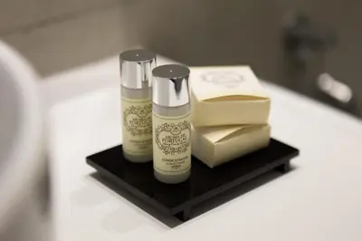 two bottles of shampoo and a box on a black shelf at Virtudes City Lofts in Porto