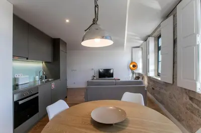 a kitchen and living room with a table and a couch at Modern 18th Century Flat in Porto
