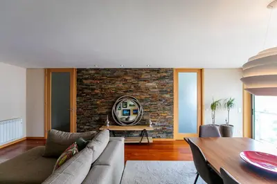 a living room with a couch and a brick wall at Comfy Luxury Apartment in Porto