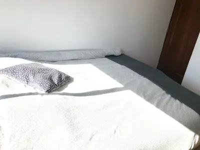 a bed with white sheets and a pillow on it at Cocooning Appartement in Porto