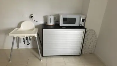 a microwave sitting on top of a counter next to a sink at Cocooning Appartement in Porto