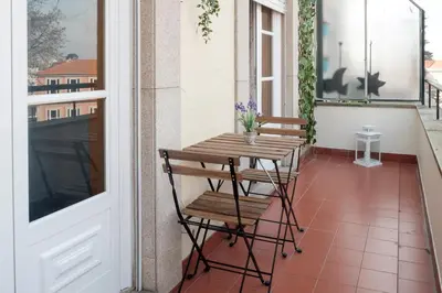 a wooden table and chairs on a balcony at apartment with balcony in the square in Porto