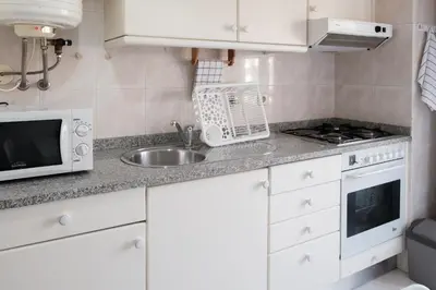 a kitchen with a sink and a microwave at apartment with balcony in the square in Porto