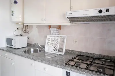 a kitchen counter with a sink and a stove at apartment with balcony in the square in Porto