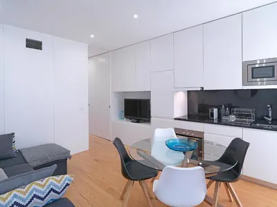 a kitchen and living room with a table and chairs at FLH Porto Balcony Apartment in Porto