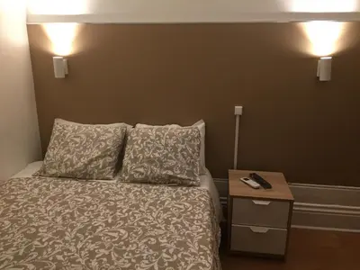 a bed with two pillows and a night stand with a nightstand at Lira Guest House B&B in Porto