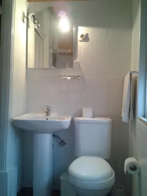a bathroom with a white toilet and a sink at Lira Guest House B&B in Porto