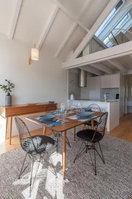 a kitchen and dining room with a wooden table and chairs at FLH Douro View Luxury Duplex in Porto
