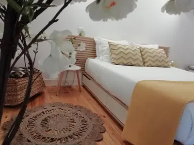 a bedroom with a bed with white sheets and pillows at Porto Feeling in Porto