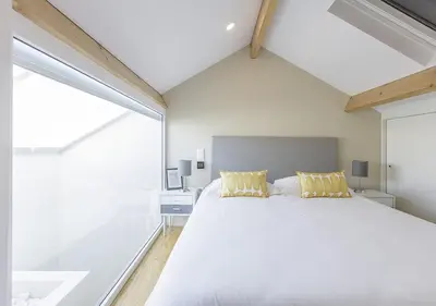 a bedroom with a large white bed with yellow pillows at Mercado dos Poetas – Tourism Apartments in Porto