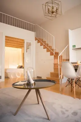 a bedroom with a bed and a table and a kitchen at Mercado dos Poetas – Tourism Apartments in Porto