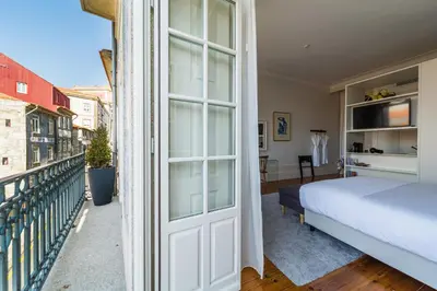 a bedroom with a bed and a balcony at Casa do Cativo in Porto