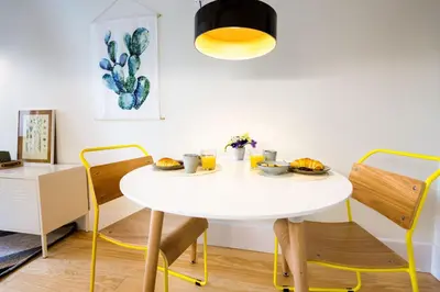 a dining room with a white table and chairs at Studio Tomás Gonzaga in Porto