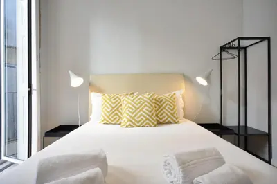 a bedroom with a large white bed with two lamps at Oporto City View - Santo Ildefonso in Porto