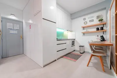 a kitchen with white walls and a table and a door at Merc Porto Bolhão Place in Porto