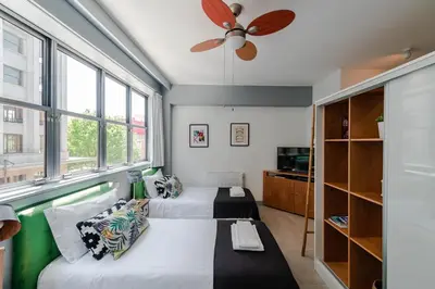 a bedroom with two beds and a ceiling fan at Merc Porto Bolhão Place in Porto