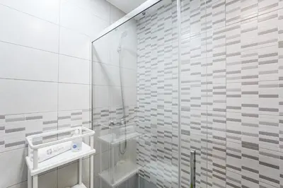 a white bathroom with a shower and a sink at GuestReady - Beautiful Plateau in Porto