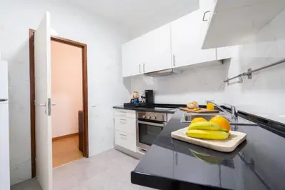 a kitchen with white cabinets and a black counter top at Renovated 3BR Apt Near City Hotspots with Great Value in Porto