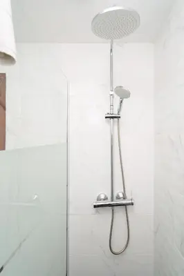 a shower with a shower head in a bathroom at Renovated 3BR Apt Near City Hotspots with Great Value in Porto