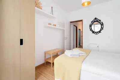 a bedroom with a table and a mirror on the wall at Renovated 3BR Apt Near City Hotspots with Great Value in Porto