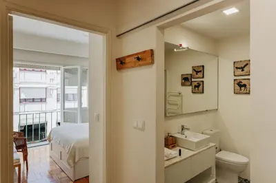 a bathroom with a sink and a bed and a mirror at Cozy 1-Bedroom with Private Terrace in Palmela in Porto