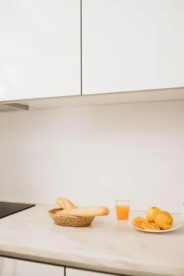 a kitchen counter with bread and a glass of orange juice at Cozy 1-Bedroom with Private Terrace in Palmela in Porto