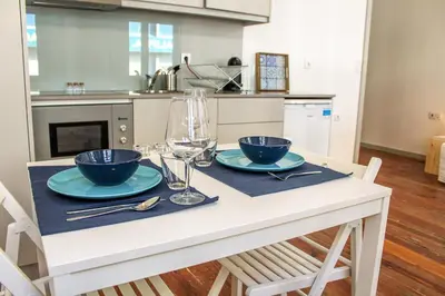 a kitchen with a table with two blue bowls on it at Bonjardim Flats - T1 in Porto