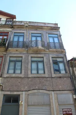 a tall brick building with windows and balconies at Bonjardim Flats - T1 in Porto