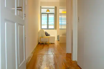 a living room with a chair and a window at Bonjardim Flats - T1 in Porto
