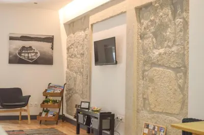 a living room with a stone wall with a mirror at Suite In in Porto