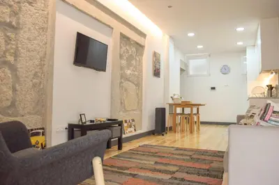 a living room with a tv on a wall at Suite In in Porto