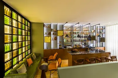a restaurant with tables and chairs and a green wall at Gallery Hostel in Porto