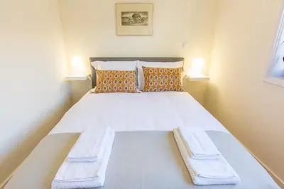 a small bedroom with a white bed with two benches at Opo Arte Apartment with terrace and A/C in Porto