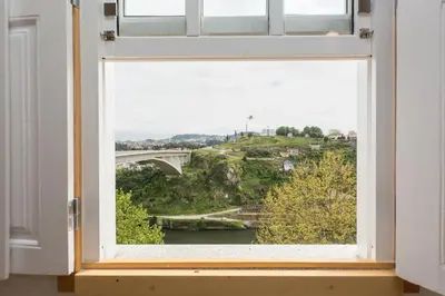 a window with a view of a bridge at Fontainhas River Residence in Porto