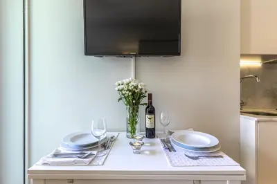 a table with plates and glasses and a bottle of wine at Charming City Centre Studio near Aliados - Inside Porto Apartments 