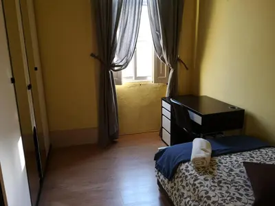 a bedroom with a bed and a desk and a window at Guesthouse Monsanto in Porto