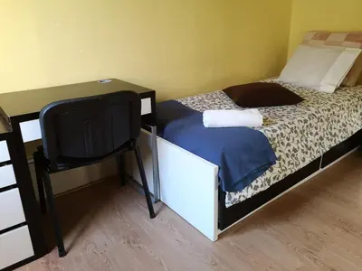a bedroom with a bed with a chair and a desk at Guesthouse Monsanto in Porto