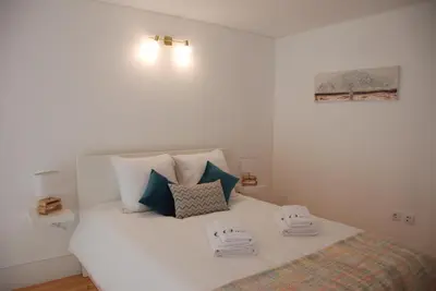 a white bed with two towels on top of it at OportoView Premium Apartment in Porto