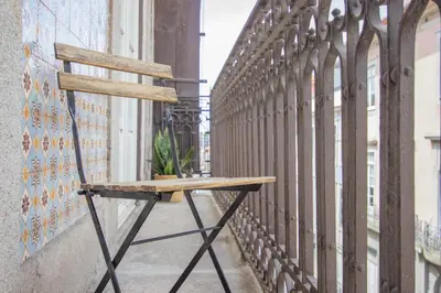 a wooden chair sitting on the side of a balcony at Formosa 79 Apartments by Guestify in Porto