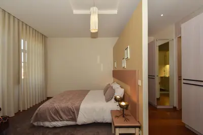 a bedroom with a bed and a table with a lamp at GR Suites in Porto