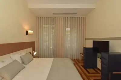 a hotel room with a bed and a television at GR Suites in Porto