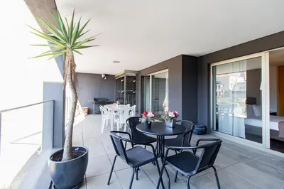 a living room with a table and chairs and a palm tree at D João IV Apartment With Terrace by LovelyStay in Porto