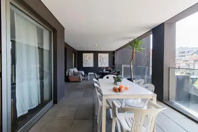 a room with a white table and chairs on a balcony at D João IV Apartment With Terrace by LovelyStay in Porto