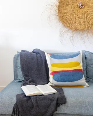 a pillow and a book on a couch with a blanket at Own Places Cedofeita Apartments in Porto