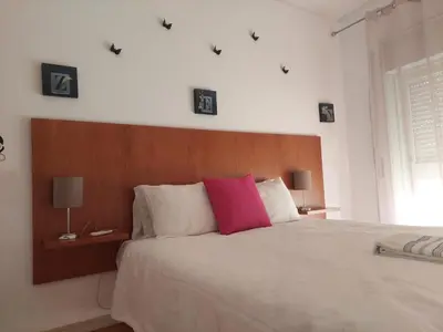a bedroom with a large bed with a pink pillow at Downtown Sunny Apartment in Porto