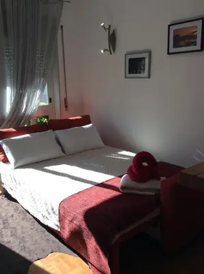 a bedroom with a bed with a red blanket on it at Downtown Sunny Apartment in Porto